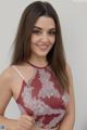 A woman in a red and white lace top posing for a picture.