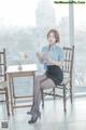 A woman sitting at a table with a cup of coffee.