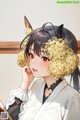 A girl in a kimono with a cat ears on her head.