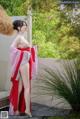 A woman in a red and white kimono posing for the camera.