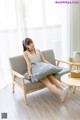 A woman sitting on a couch with a pillow on it.