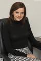 A woman sitting in a black chair in an office.