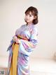 A woman in a blue and yellow kimono posing for a picture.