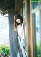 A woman leaning against a window looking out of a window.